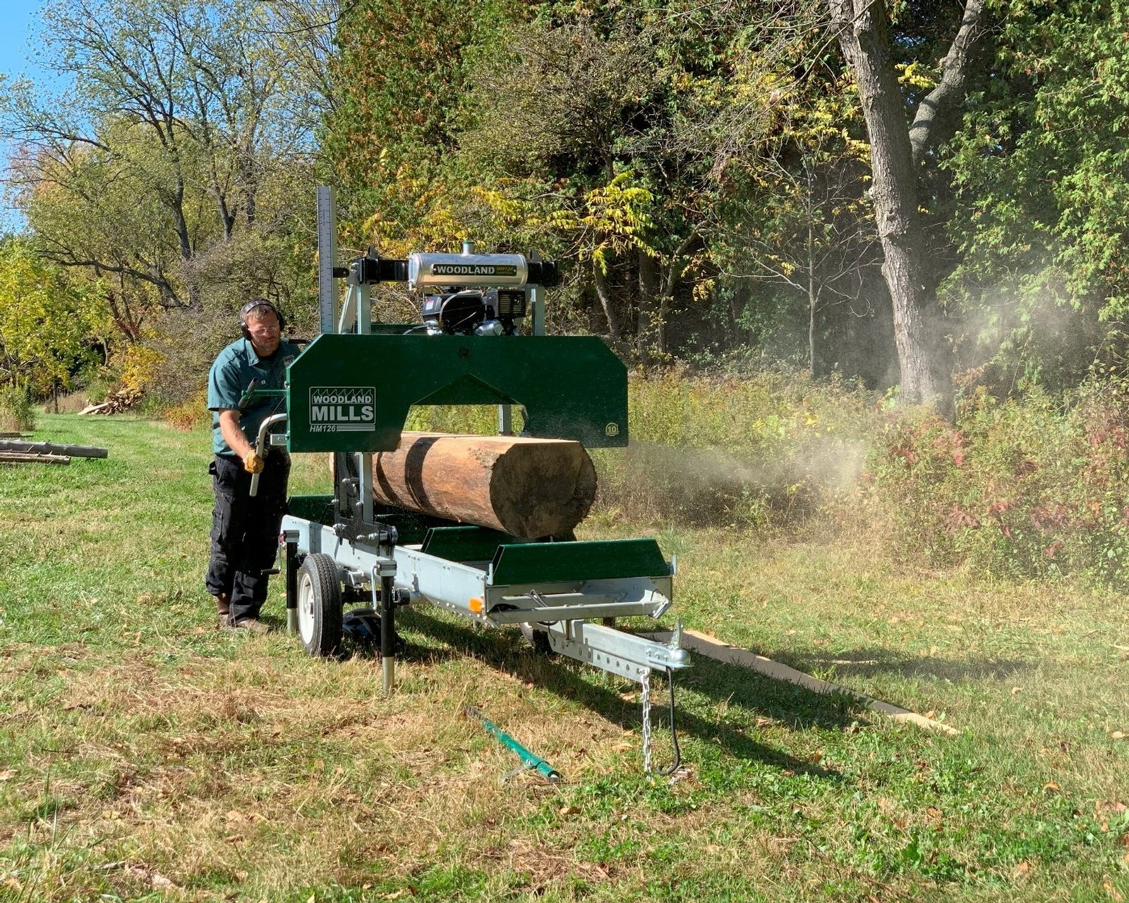 Operator cutting a log with a Woodland Mills portable bandsaw mill